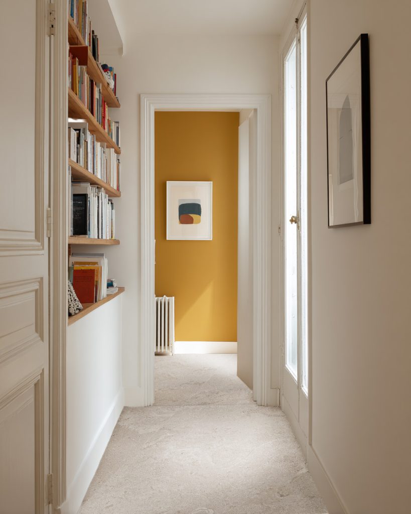 Couloir avec carrelage avec pierre clair collection Kairn Bibliothèque et mur jaune
